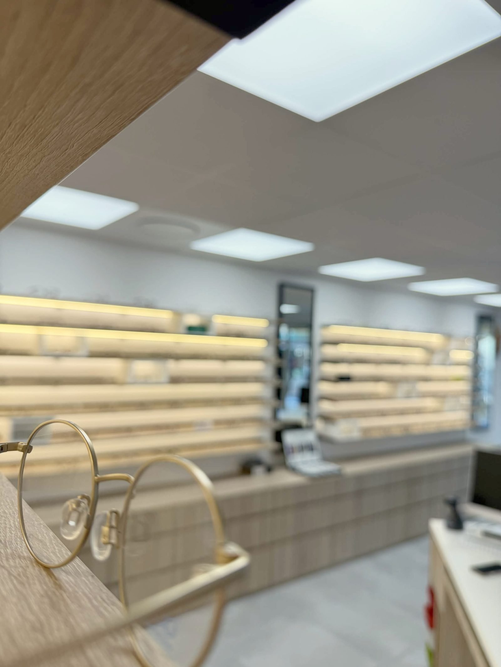 Monture ronde dorée au premier plan, la boutique en arrière-plan